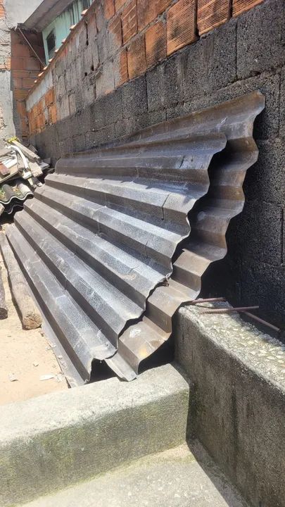 Telhas de zinco, pedaços de madeira, caixa d'água