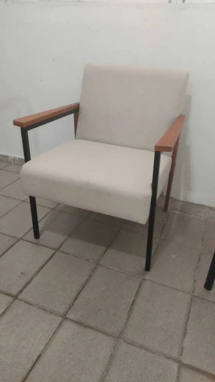 Poltronas de linho com estrutura em metal e detalhes em madeira.