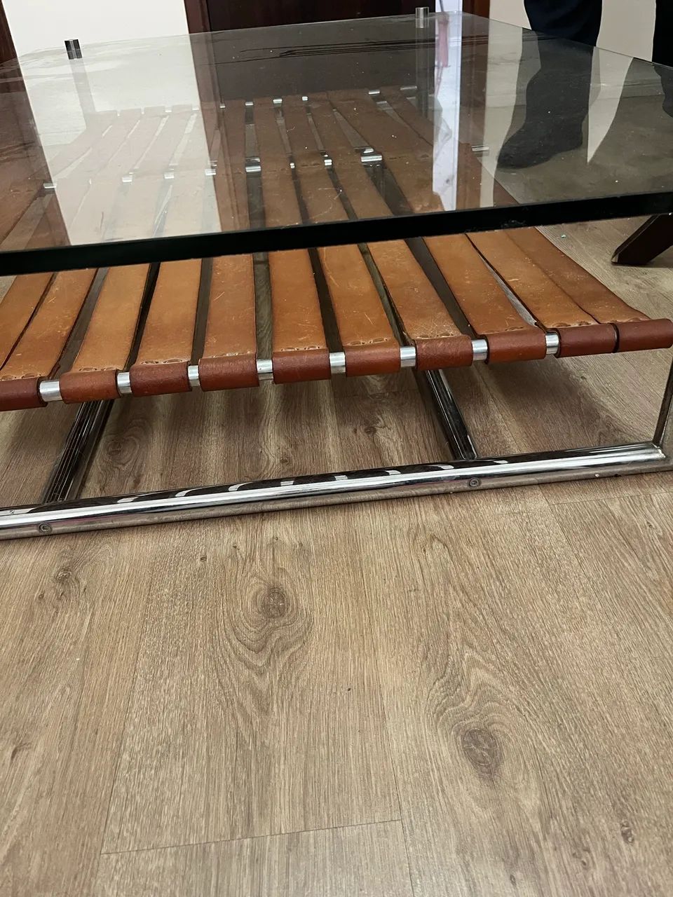 Mesa de centro  com tampo de vidro, base inox  detalhado em couro.