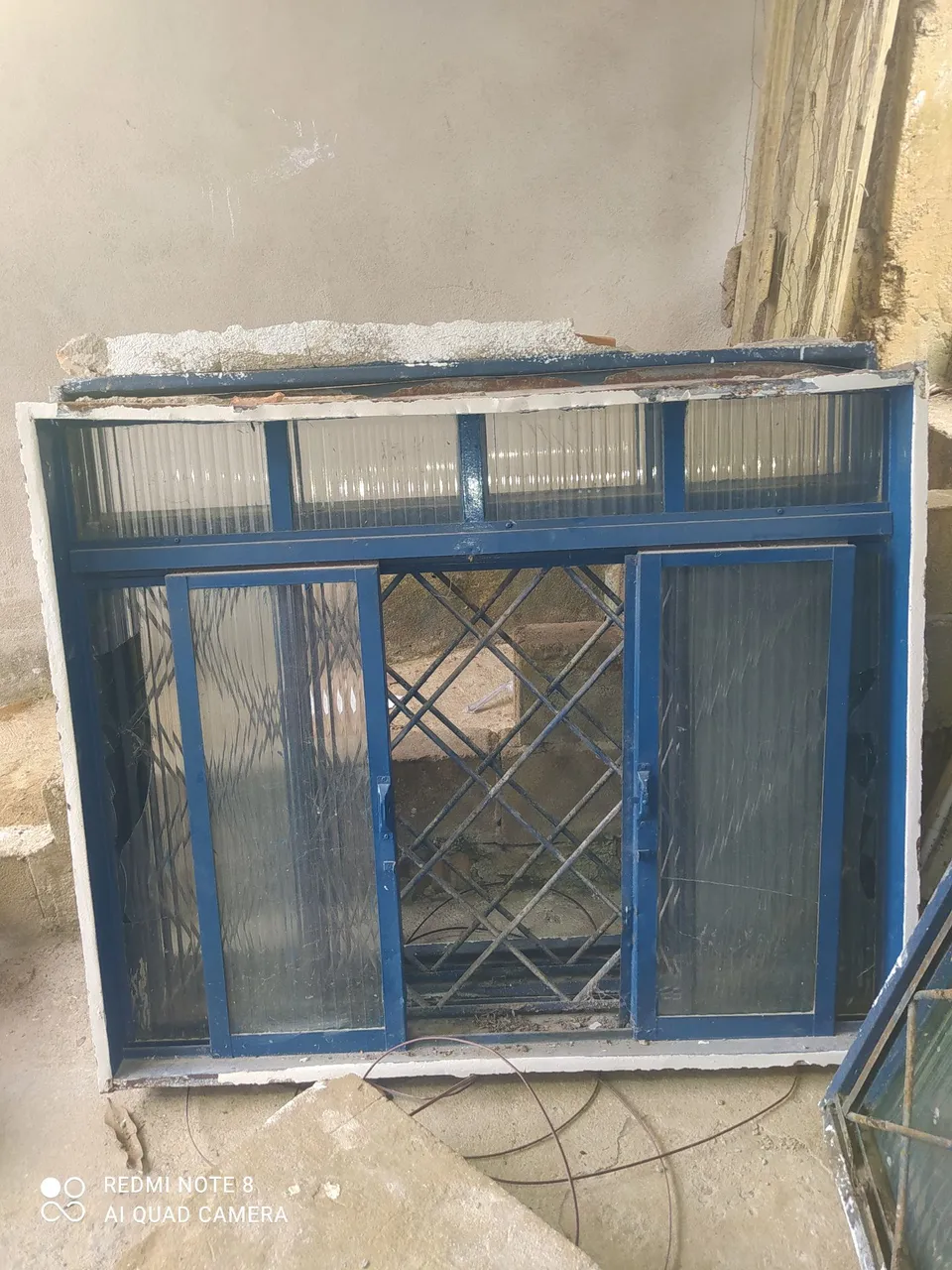 Janela de aço com grade e veneziana