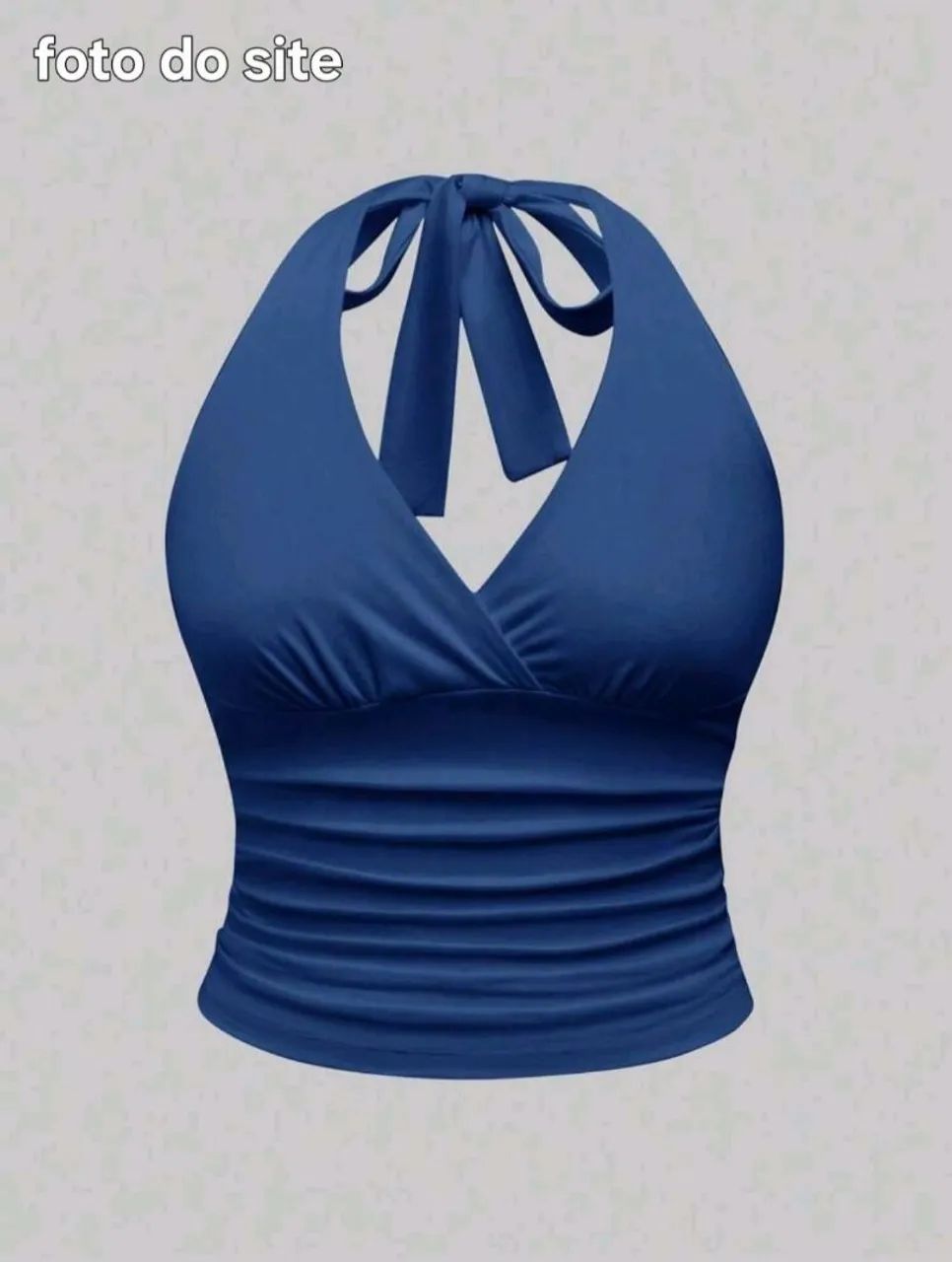 Blusa azul com alcinha de amarrar e meio decote na frente.
