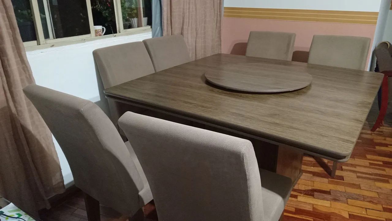 Mesa quadrada de madeira com seis cadeiras.