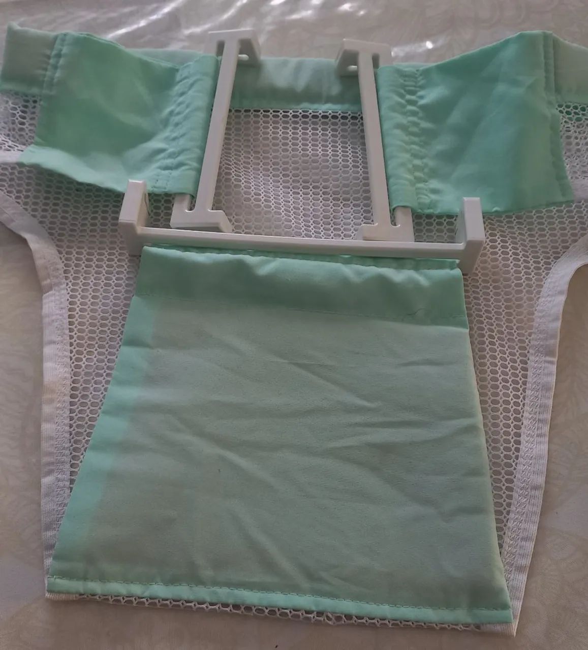 Um protetor  de banheira  de bebê   verde e branco  ótimo  estado.