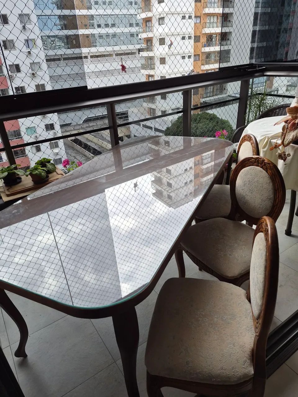 Uma mesa de madeira com tampo de vidro e 6cadeiras