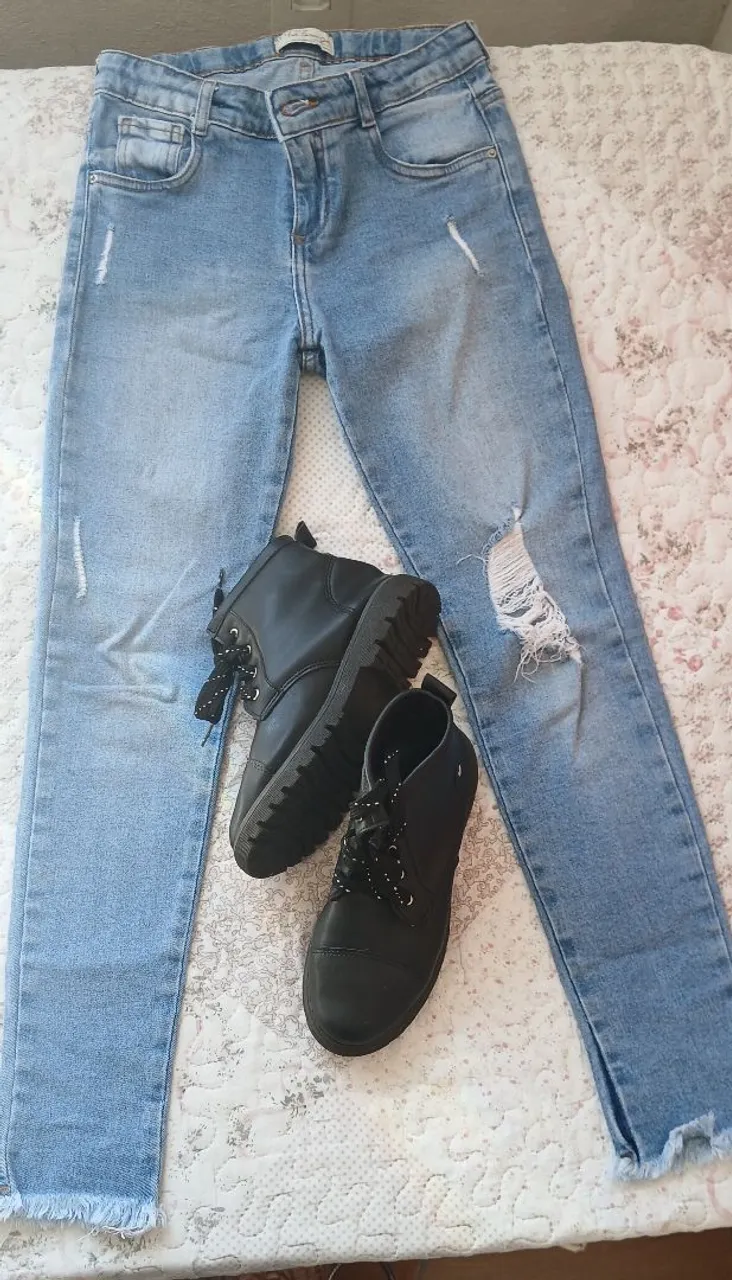 Calça jeans com detalhes rasgados e botinhas