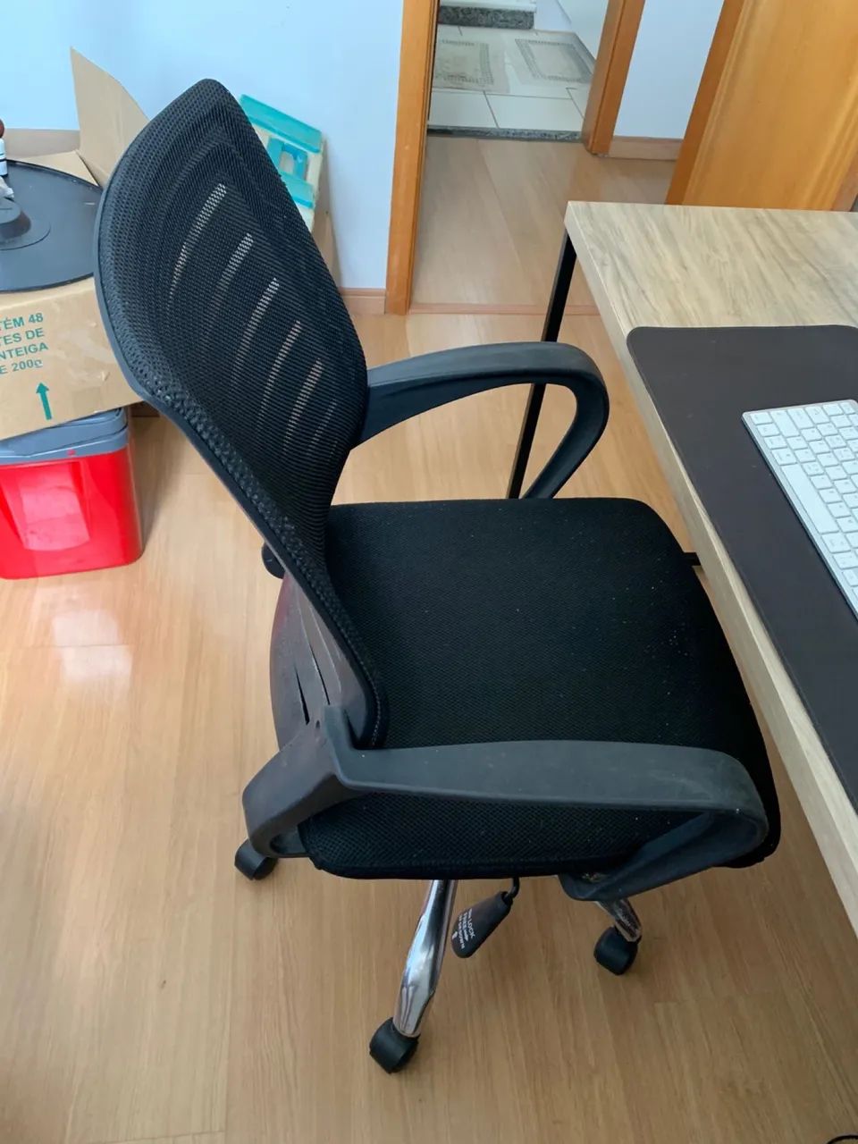 Cadeira de escritório preta com encosto em tela e base cromada