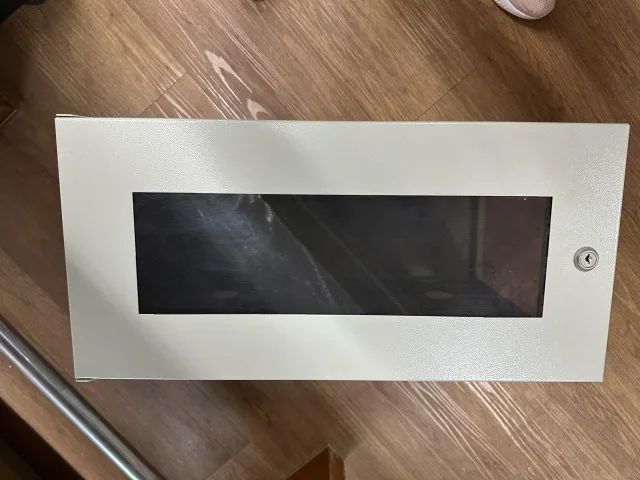 Caixa metálica bege com parte da frente transparente 