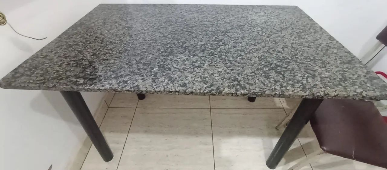 Mesa de mármore com cinco cadeiras.