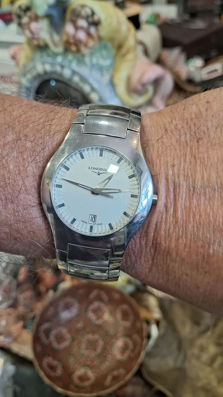 relógio é um Longines Oposition em aço inoxidável com mostrador branco.