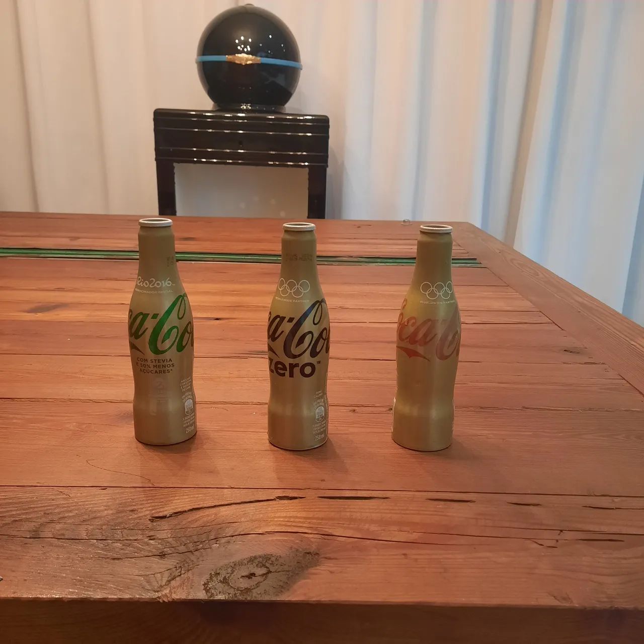 Tres garrafas colecionáveis douradas da Coca Cola 