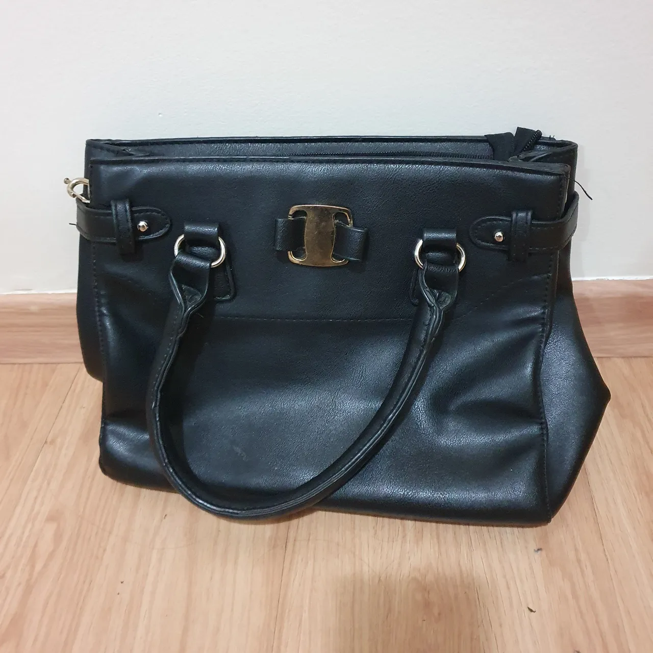 Bolsa preta elegante com detalhes dourados
