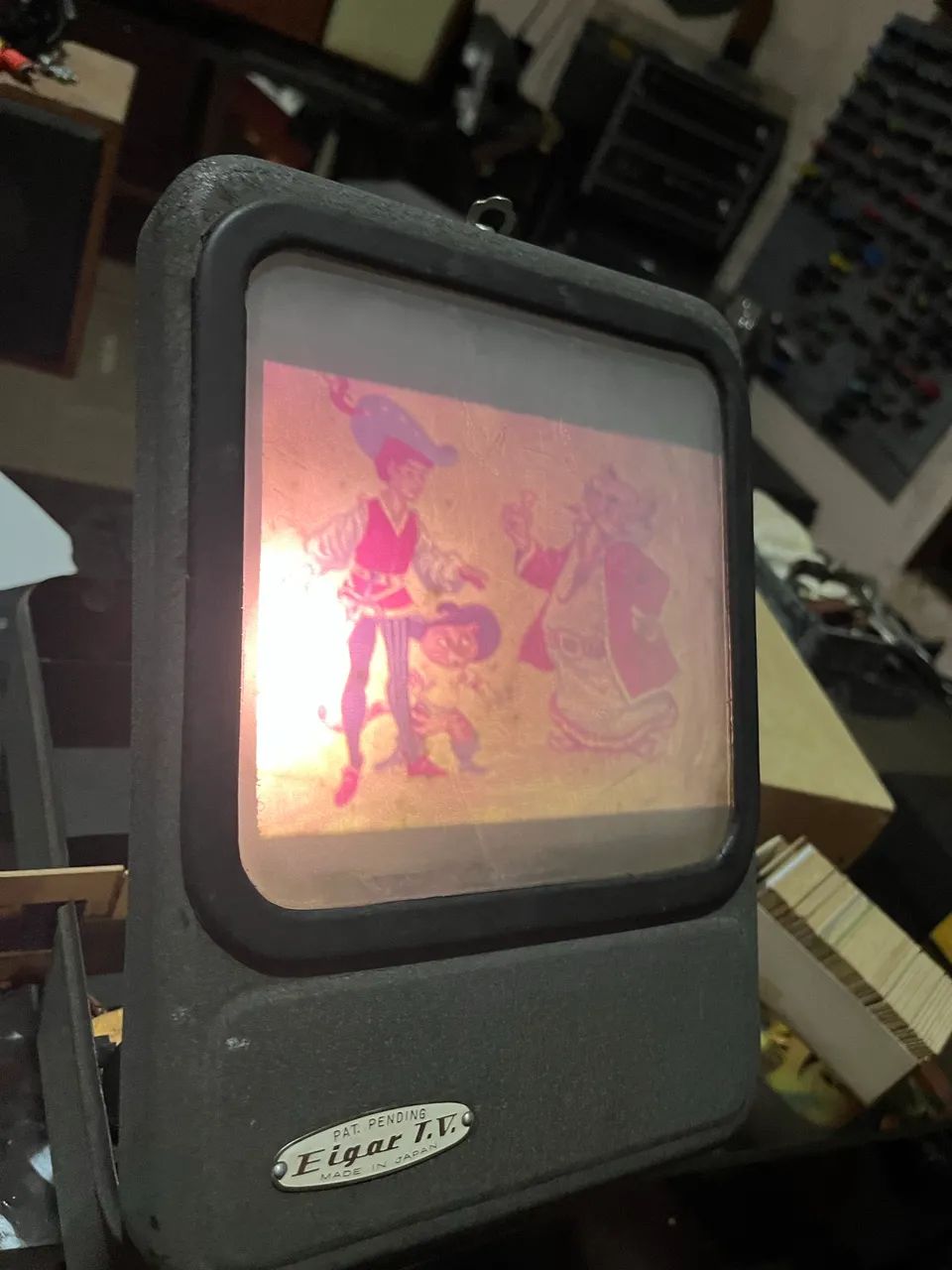 mini televisor ou um projetor de imagens estáticas, da marca "Eigar T.V."