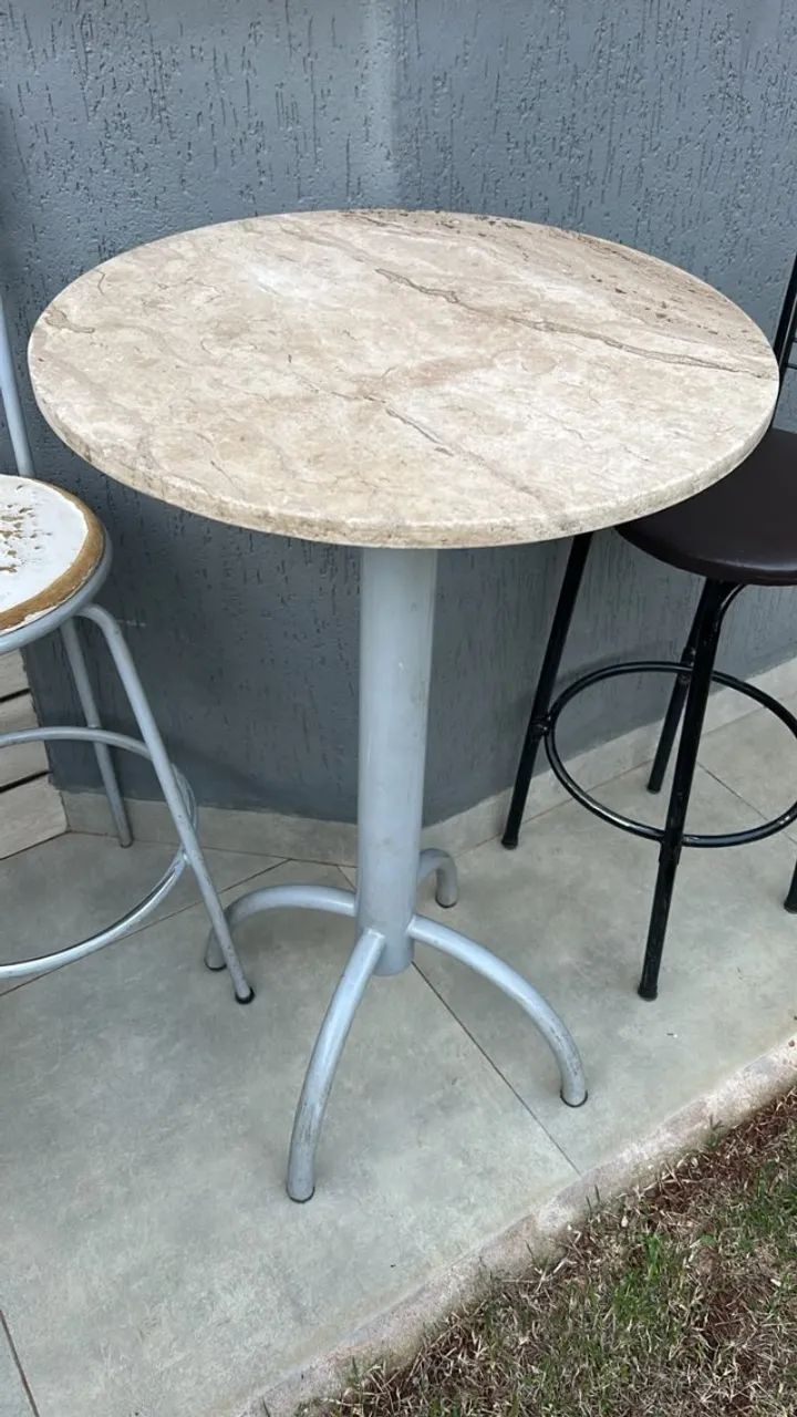 Mesa bistrô com tampo em granito e 2 banquetas metálicas.
