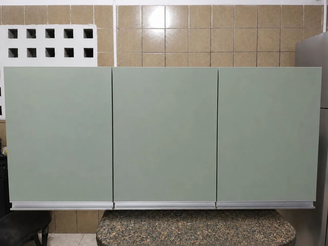 Armário aéreo branco com porta verde