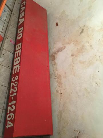 Toldo vermelho vertical com estrutura de ferro