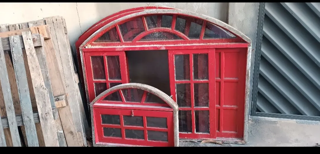 Janela, porta e báscula de madeira vermelha com detalhes em arco