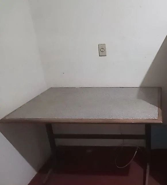 Mesa de madeira com tampo similar a granito e pés de ferro 