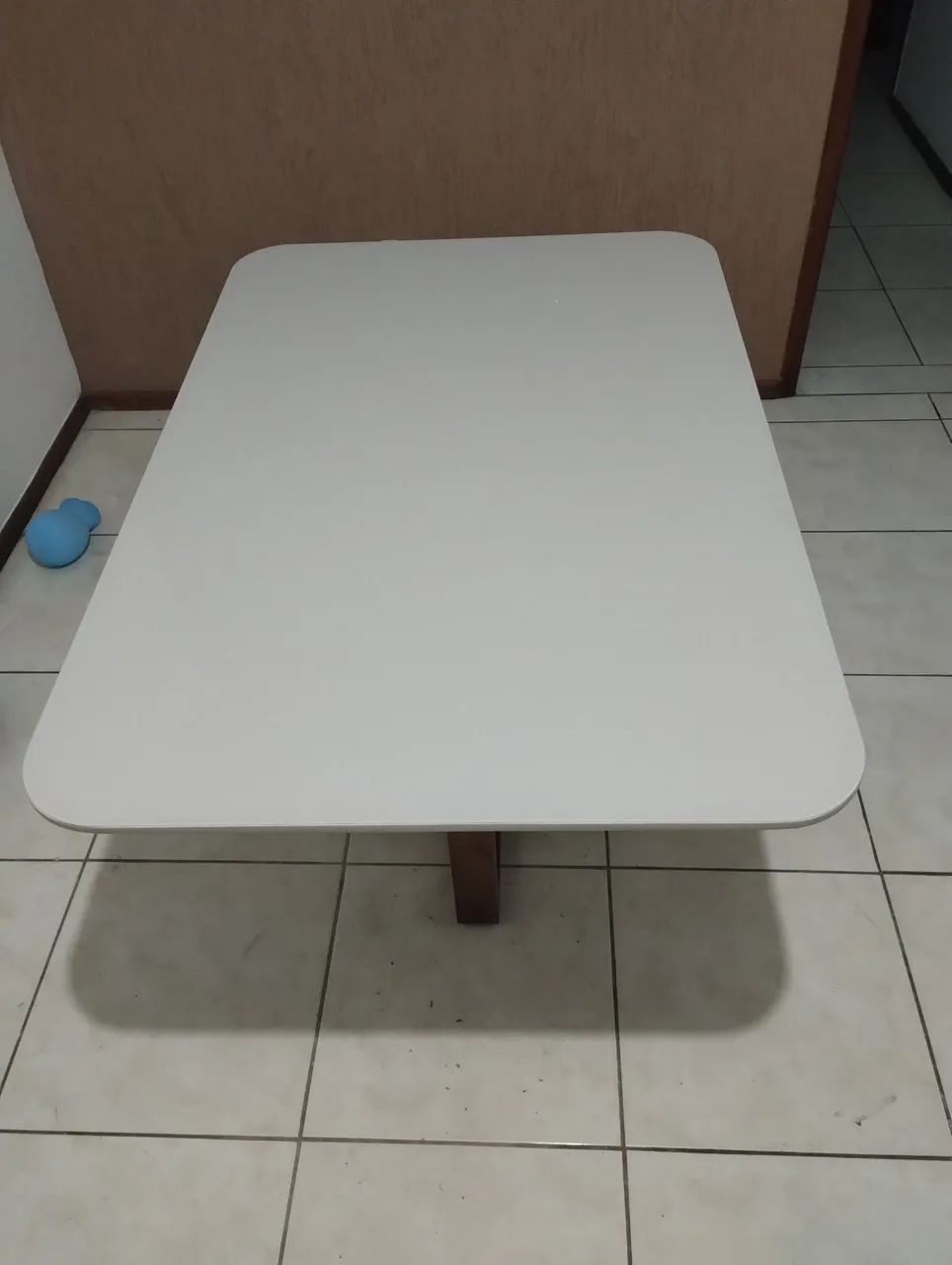 Mesa de jantar retangular com tampo de vidro.