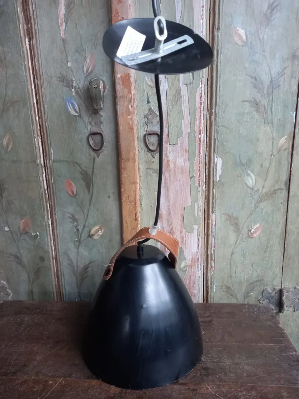 Pendente de teto preto com alça de couro.