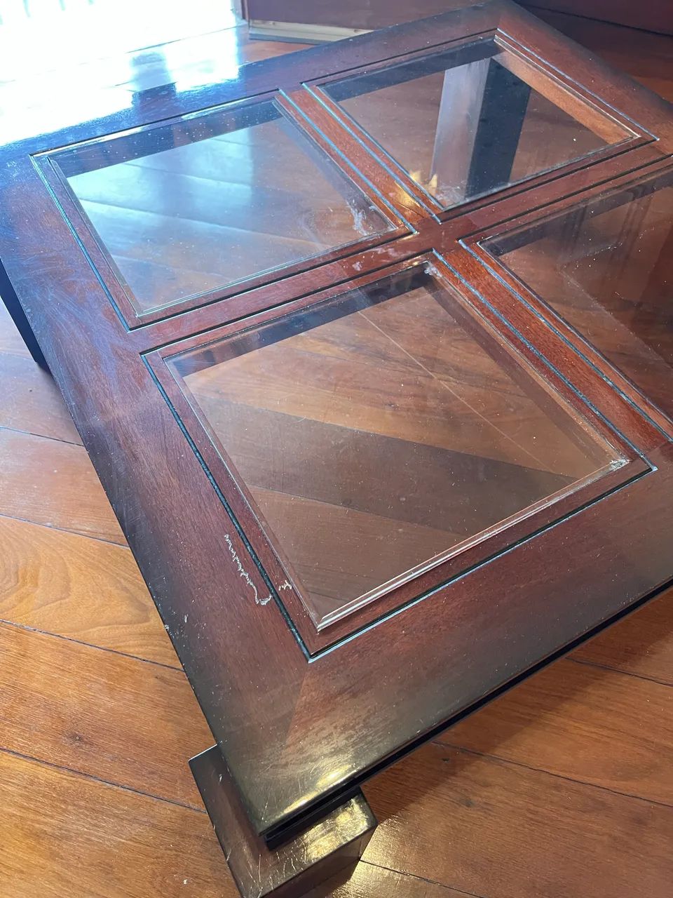 Mesa de centro em madeira maciça com tampo de vidro.