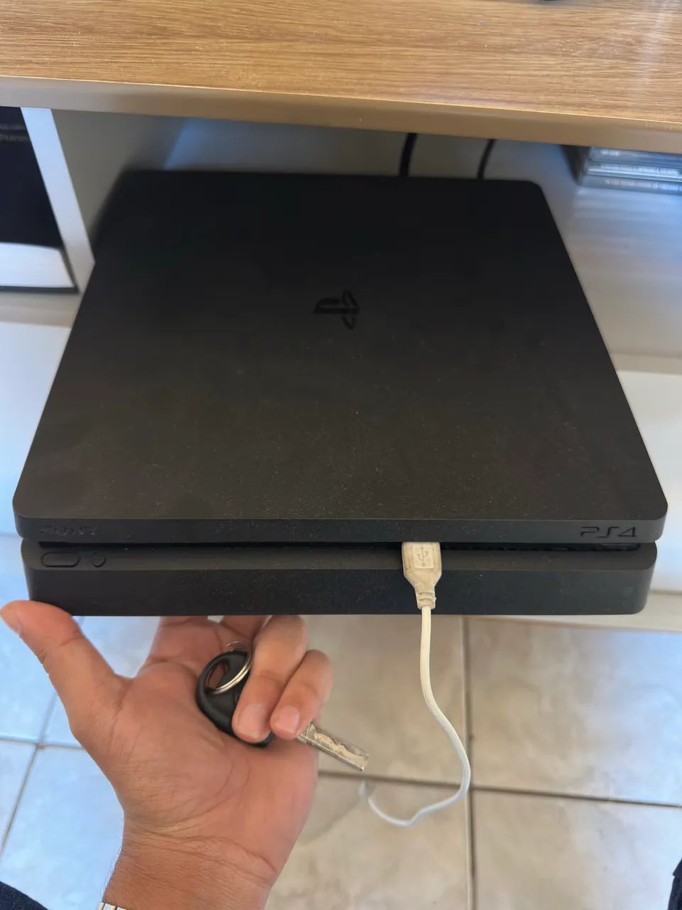 PS4 1 TB com duas manetes e jogos.