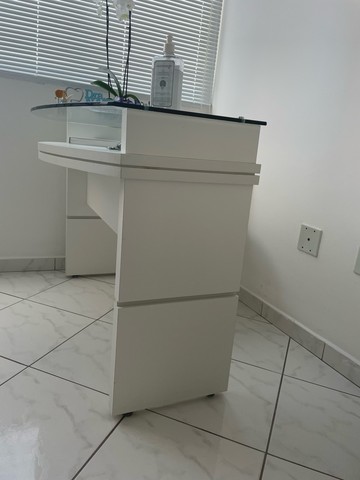 Mesa de madeira branca com tampo de vidro. Ideal para consultório.