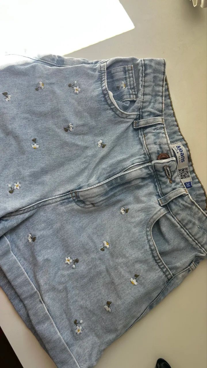 Short jeans mom cintura alta com flores bordadas