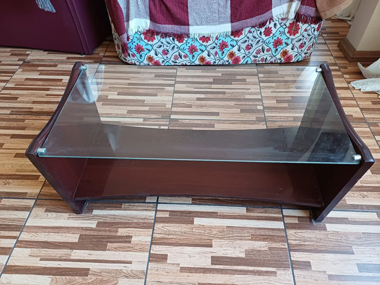 Mesa de centro na cor mogno, com tampo de vidro, com design moderno e elegante.