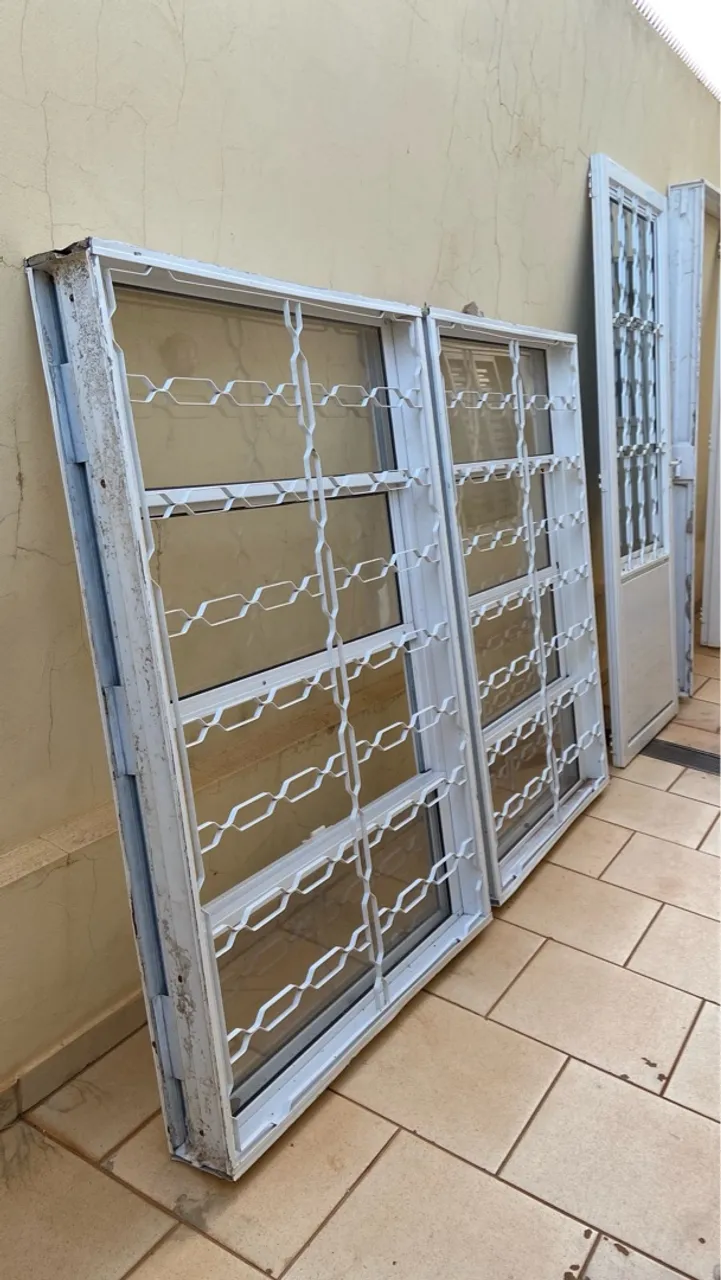 Janelas de aço branca com grade de proteção