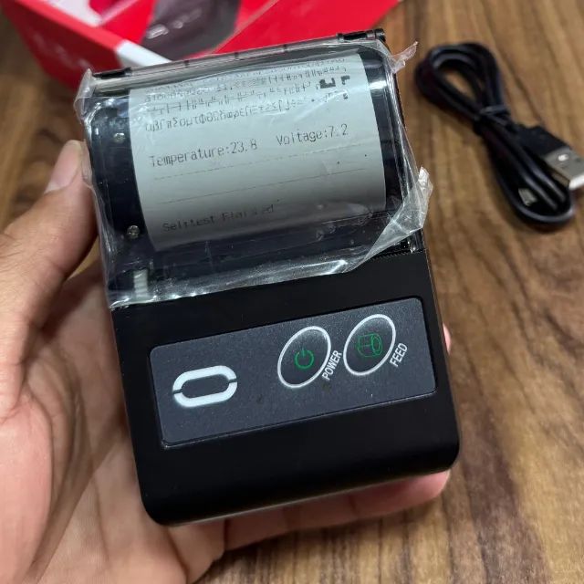 Impressora térmica portátil imprimindo um recibo.