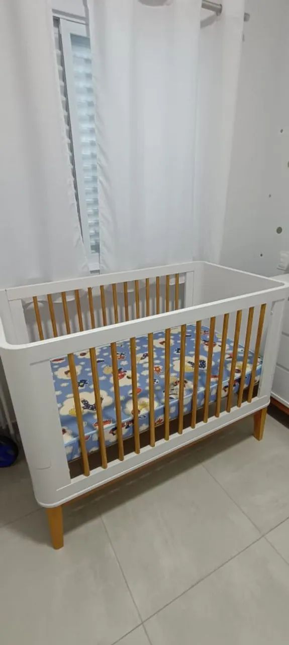 Berço branco com detalhes em madeira