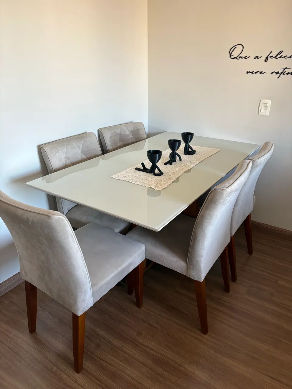 Cadeiras e mesa de jantar com tampo de vidro e pés de madeira 