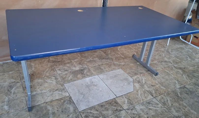 Mesa para escritório azul com pés de aço.