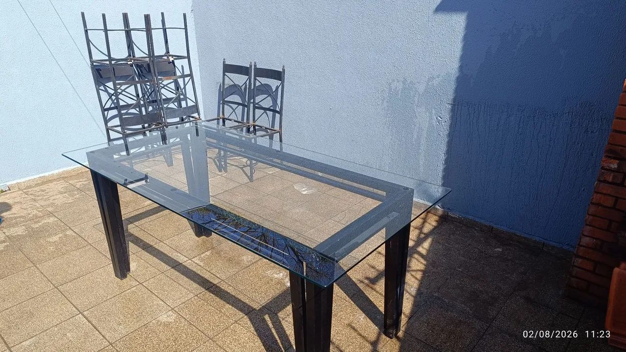 Mesa de vidro e jogo de cadeiras em ferro.