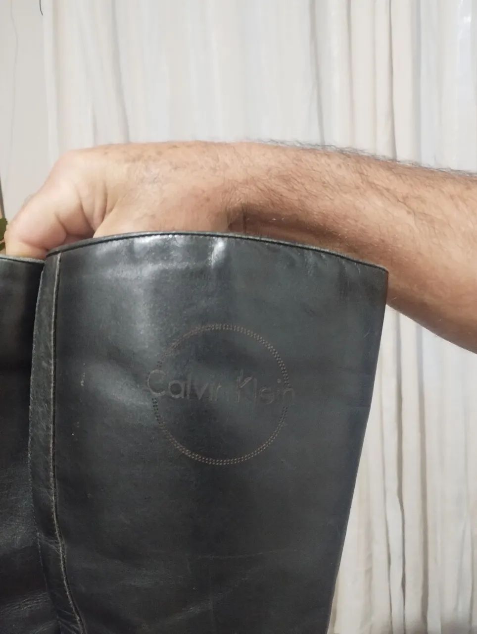 Duas botas uma preta e uma marrom 