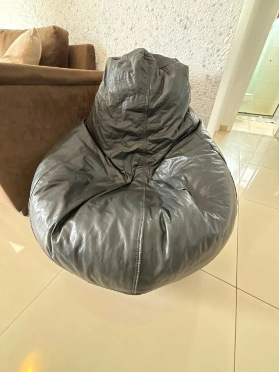 Puf em couro preto que se  molda ao formato da coluna ao sentar. Conforto e modernidade.