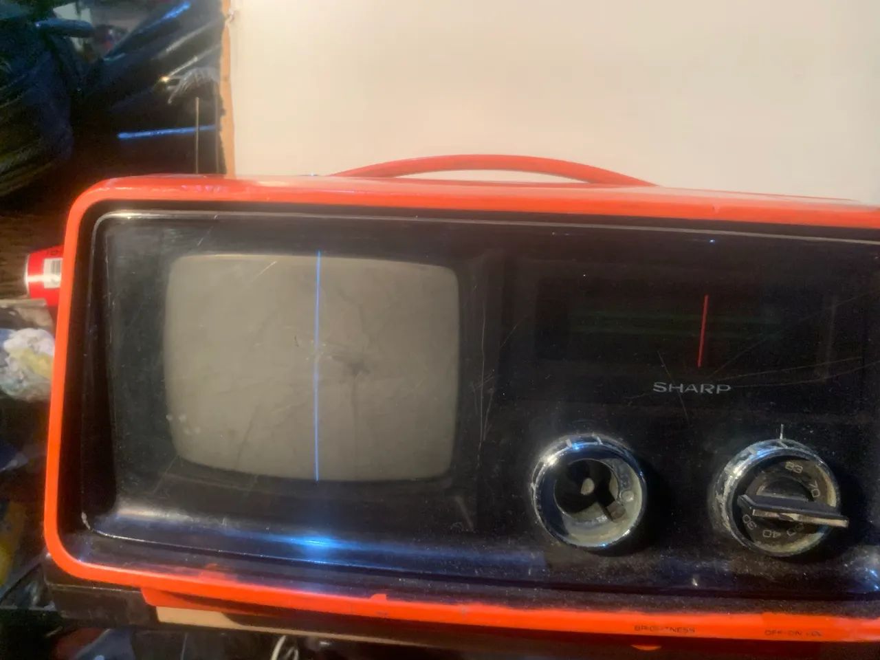 televisão Sharp portátil de estilo vintage com uma carcaça laranja vibrante.