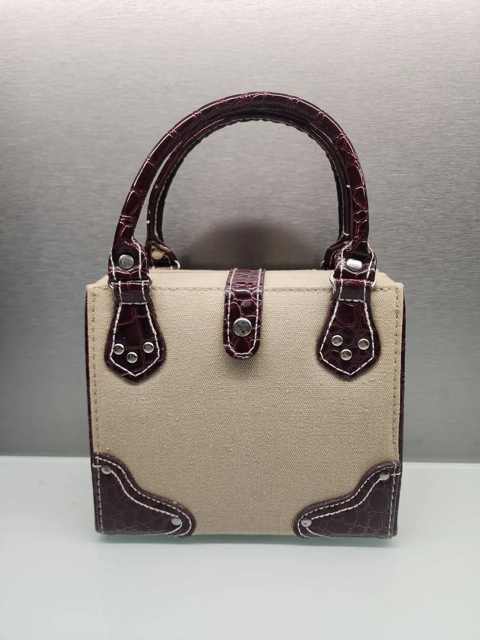 Bolsa de mão bege com detalhes marrom vintage.