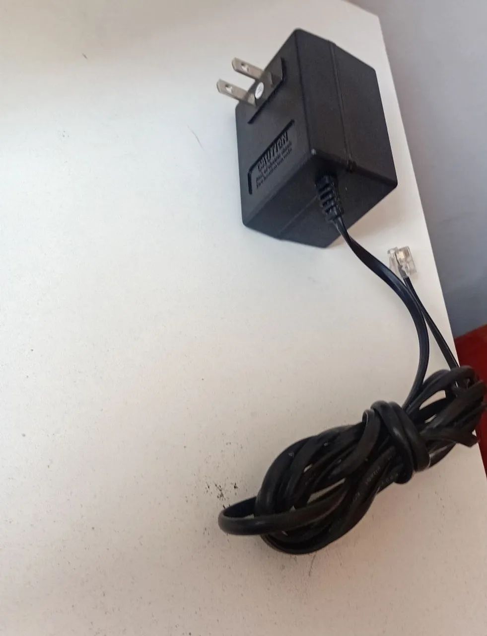 adaptador AC da marca Intelbras. 