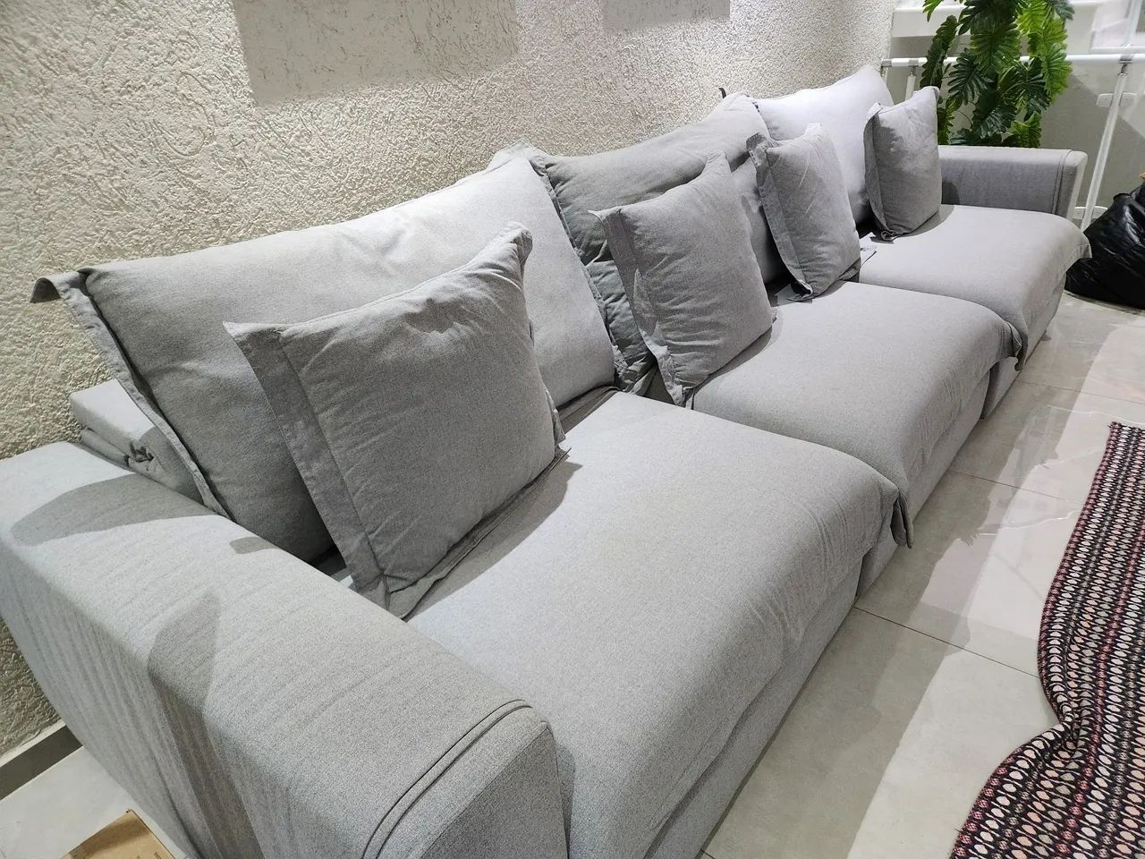 Sofá retrátil na cor cinza, capacidade para 7 pessoas sentada
