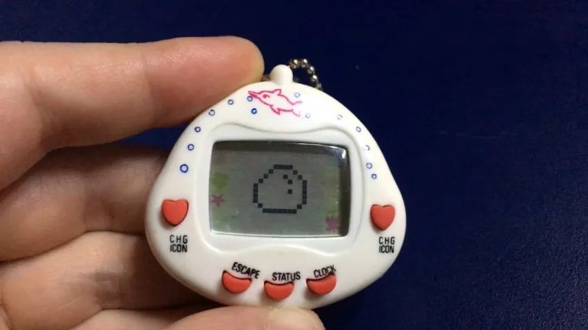Bichinho Virtual RakuRaku Dinokun TK-910 Branco (Tamagotchi) Anos