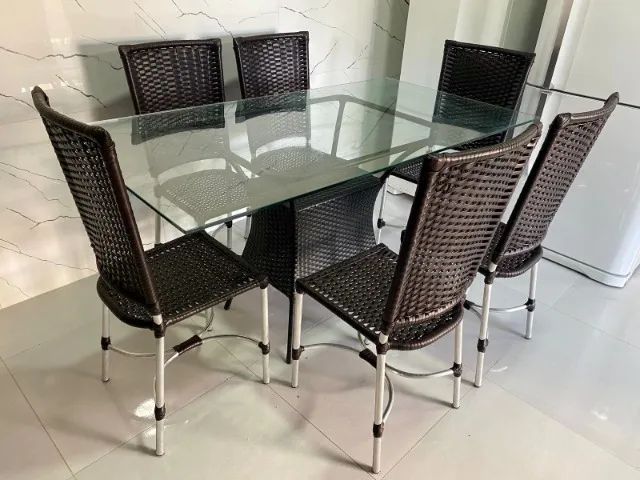 Mesa em vidro e cadeiras em alumínio.