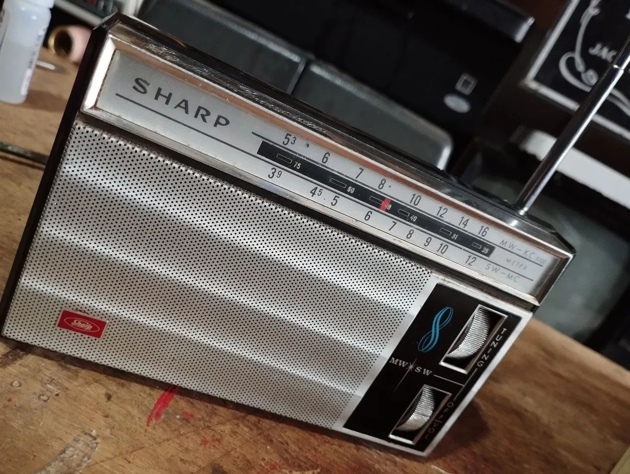 Rádio antigo de mão Sharp AM, funcionando.