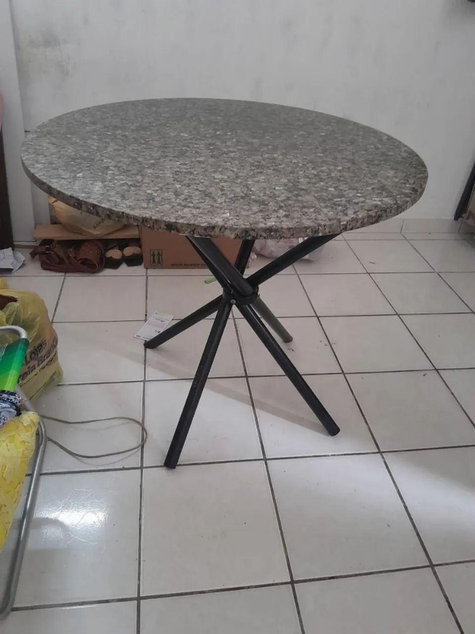 Mesa redonda com tampo de granito. 