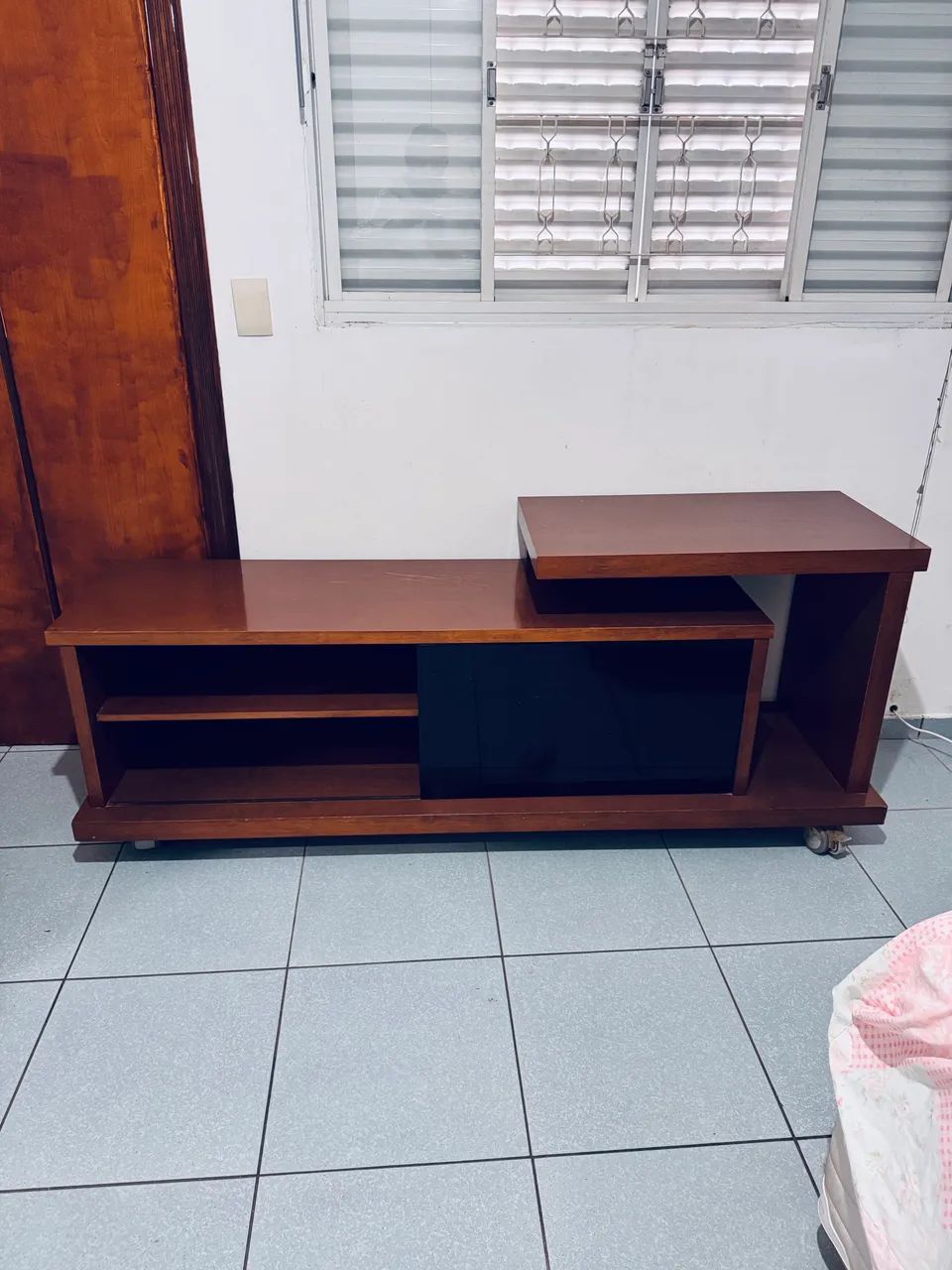 Rack para TVs com porta em vidro escuro e rodinhas 