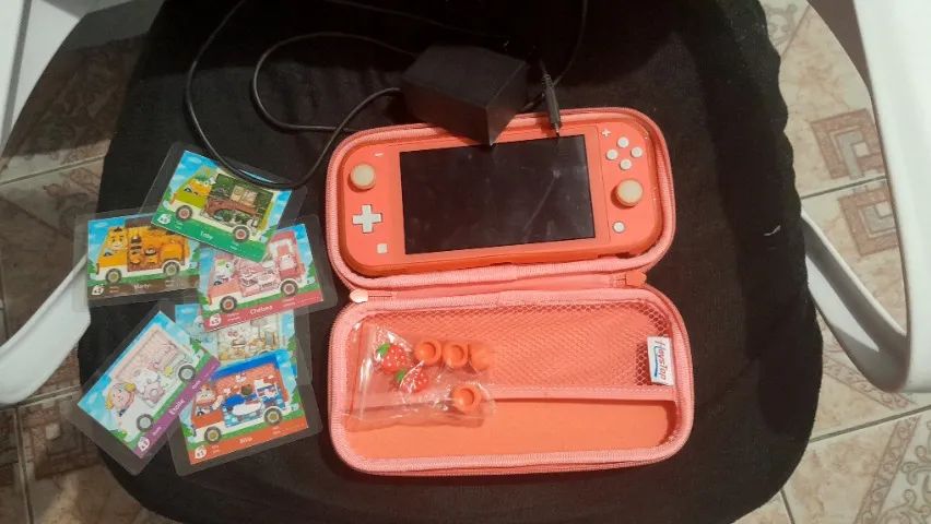 Nintendo switch coral lite na caixa com jogos, acessorios, e amiibo animal crossing