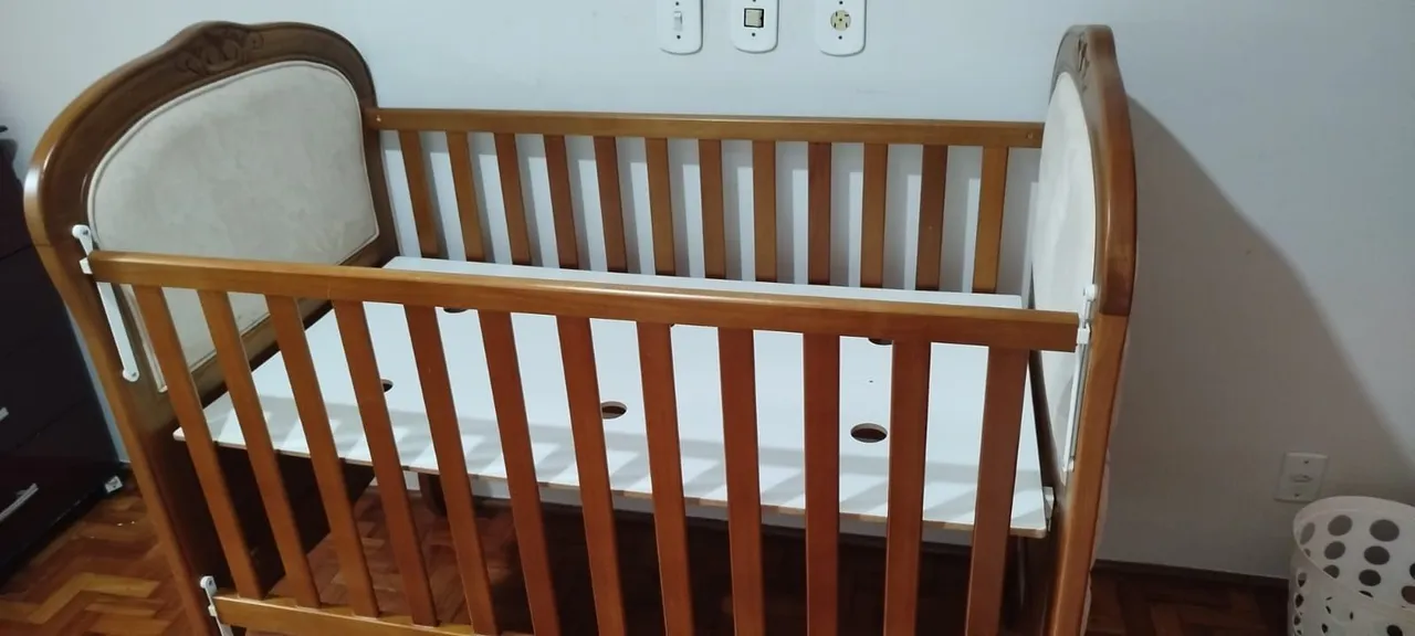 Berço de madeira com detalhes em tecido almofadados