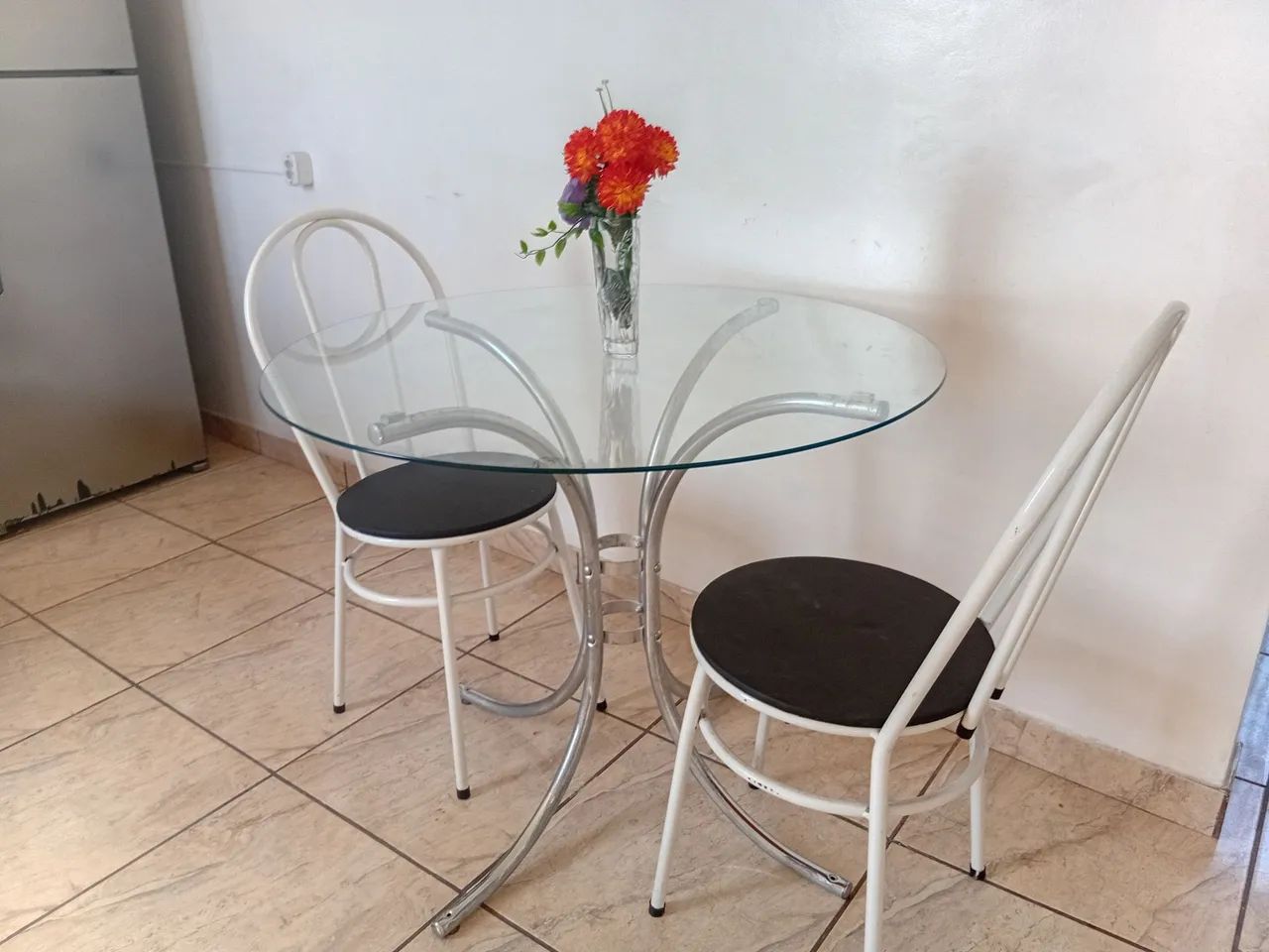 Mesa de vidro com 2 cadeiras.