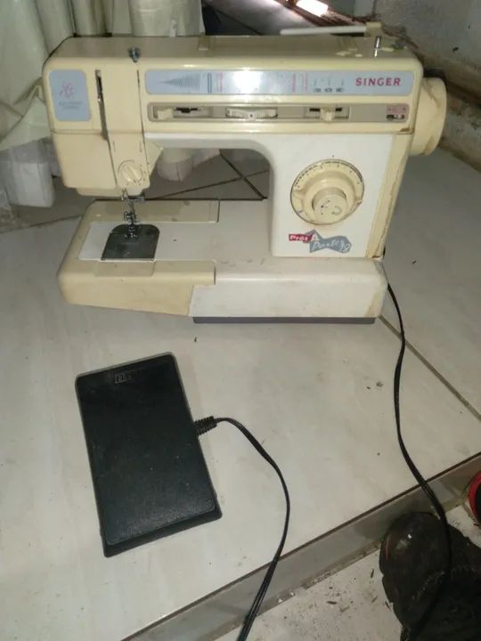Máquina de Costura Singer  estava quardadar  não  sei que está funcionando 