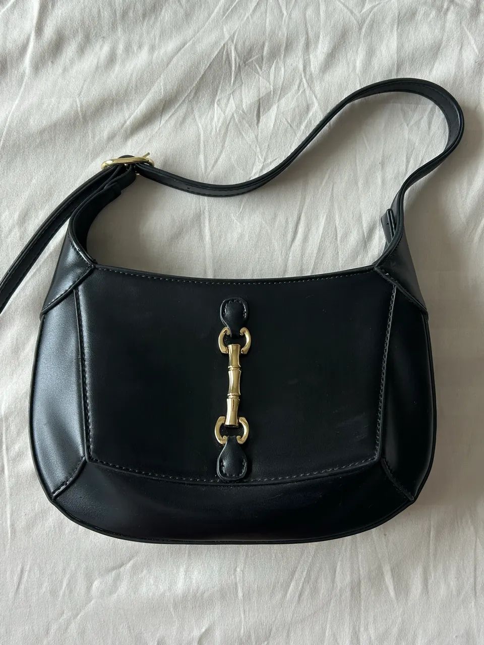 Bolsa de ombro preta com detalhe dourado 